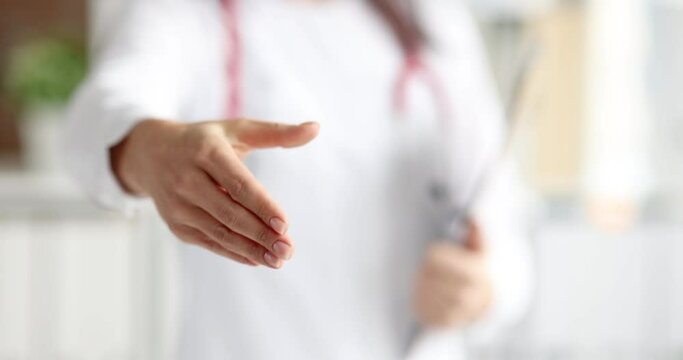 Doctor stretching out his hand for handshake in clinic closeup 4k movie slow motion. Medical partnership concept