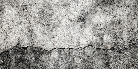 Fractured concrete wall or floor. Damaged wall background. Gray grunge cement surface with large cracks