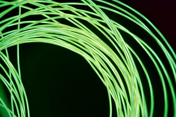 Bright and unusual photos of thin glowing wires, lime, yellow, green burning wire in the dark.