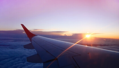 The sunset scene with Scenic View of the Wings of a aero plane flying above the clouds. Travelling...