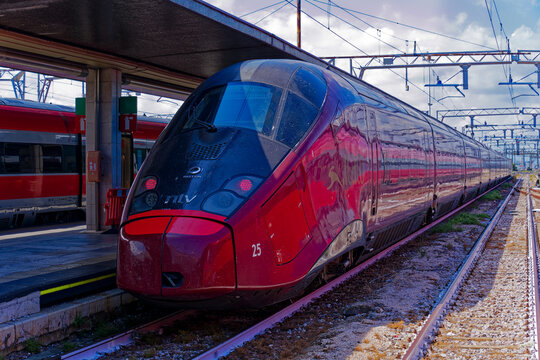 Red Italo ntv high speed train at railway station of the old town of Venice on a blue cloudy summer afternoon. Photo taken August 6th, 2023, Venice, Italy.