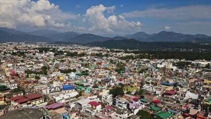 An aerial view of Dehradun, an Indian city during sunrise or sunset, with cloudy weather and rows of residential houses.
