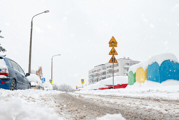 Poland, Krakow, 12.03.2023, snowfall, snowy street with cars after a blizzard