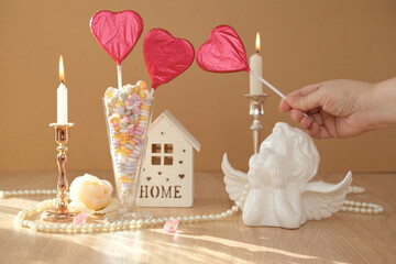 romantic still life in love style, in a glass vase red hearts on sticks, colorful candies, candles...