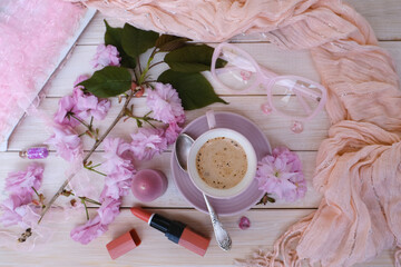 cup with drink coffee cappuccino, lipstick, pink sakura flowers, female life, caffeine improves...