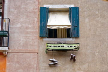 Old town of City of Venice with close-up of open window with football scarf of Venice football club on a blue cloudy summer day. Photo taken August 6th, 2023, Venice, Italy.