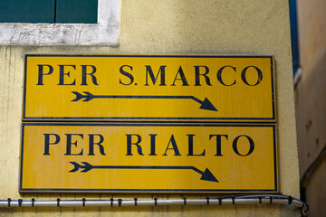 Old town of City of Venice with direction signs to San Marco square and Rialto Bridge on a sunny summer day. Photo taken August 7th, 2023, Venice, Italy.