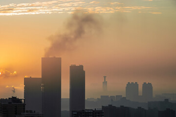 Fototapeta premium smoke in the sky, pollution on the city, sunset with skyscrapers