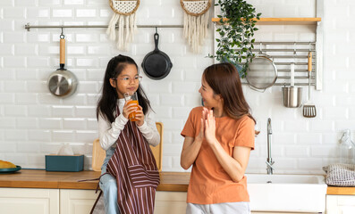 Portrait of enjoy happy love asian family mother with little asian girl preparing drinking glass of...