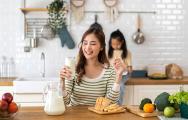 Portrait of beauty healthy asian woman smiling and having protein breakfast drinking and hold glasses of milk of fresh milk, nutrition,calcium and vitamin,dairy product in kitchen at home.Diet concept - obrazy, fototapety, plakaty
