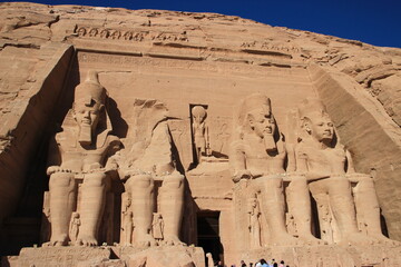 Temple Abou Simbel , Egypte : Entrée , statues de Ramses ii et bas relief Horus avec touristes...
