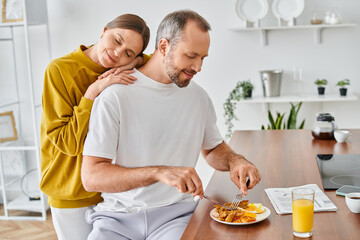 Obraz na płótnie Canvas loving woman with closed eyes leaning on husband enjoying delicious breakfast, child-free lifestyle