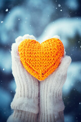 A woman holds a knitted heart in her hands. Selective focus.