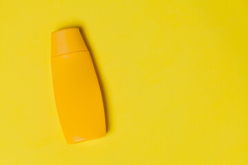 Yellow sunscreen bottle on colored background. Sunscreen concept. Skin care concept. Space for...