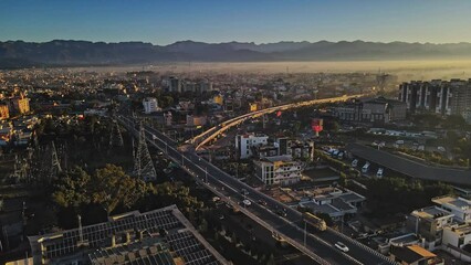 Aerial footage of the bustling Indian city Dehradun, showcasing moving traffic on the flyover near ISBT, Dehradun, Uttarakhand, India.