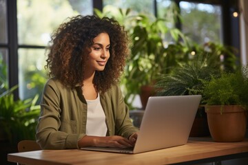 Hispanic young woman using laptop at home for online shopping
