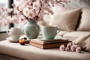 Foto op Plexiglas Cup of coffee and vase with blooming branches on sofa in room © Viewvie