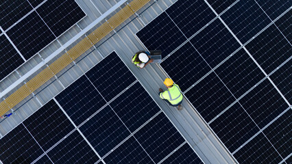 Bird's eye view from a drone of a team of engineers laying out a solar panel system outside a...