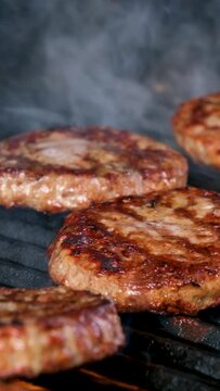 Cooking burgers on a hot grill with a flame Beef cutlets cooked on a barbecue grill.Cooking beef and pork patty for party.