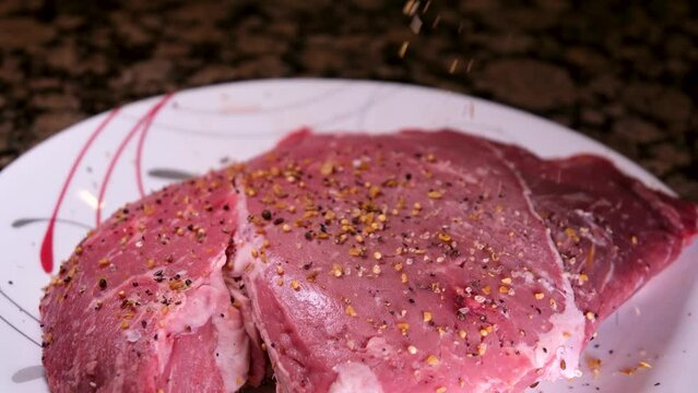 Grilled meat steak on stainless grill depot with flames on dark background. Food and cuisine concept.