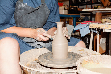 Unrecognizable potter working with clay in workshop