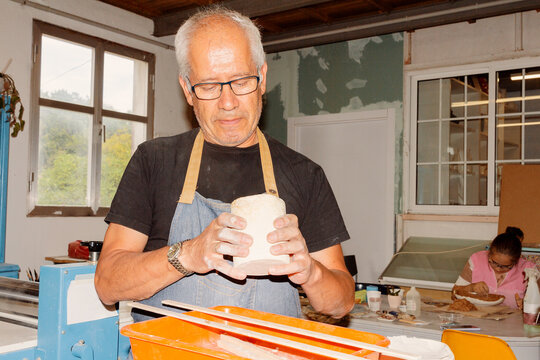 Senior man artisan working in pottery workshop