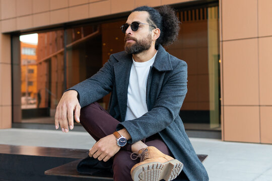 Urban style fashion man sitting outdoors