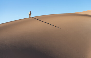 Silhouette of a tourist walking on the sand in the dunes, Great Sand Dunes National Park, Preserve Colorado, USA