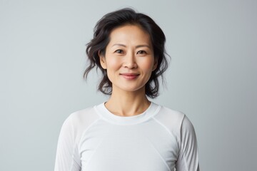 Portrait of a content asian woman in her 40s sporting a breathable mesh jersey against a white background. AI Generation