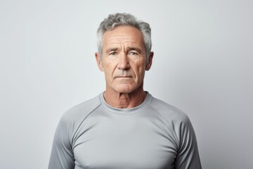 Obraz premium Portrait of a content man in his 60s sporting a breathable mesh jersey against a white background. AI Generation
