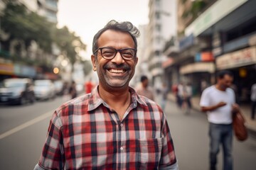 Portrait of a satisfied indian man in his 50s wearing a comfy flannel shirt against a busy urban street. AI Generation
