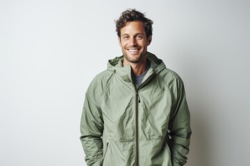 Portrait of a grinning man in his 30s wearing a lightweight packable anorak against a modern minimalist interior. AI Generation