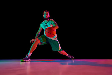 Full-length portrait of basketball player training dribbling technique and making powerful slam...