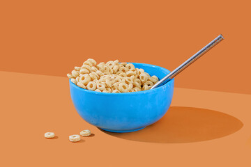 Blue bowl of cereal with milk on an orange background