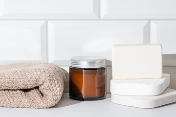 Spa essentials with towel, soap, and candle on counter