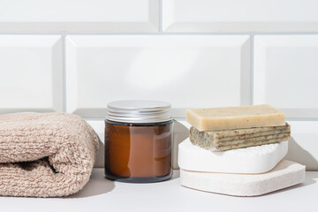 Spa essentials with natural soap and towel on white surface