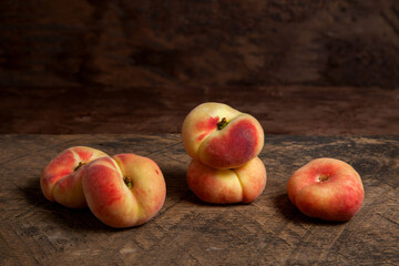 Several saturn peaches or flat peaches on wooden background.. © kostik2photo