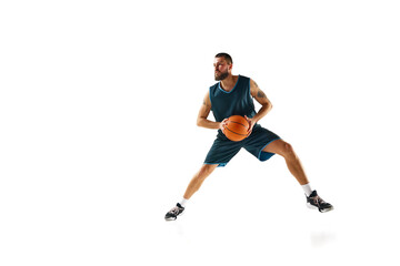 Fototapeta na wymiar Full length portrait of athletic man, professional basketball player actively training before match against white background.