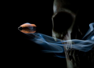 Human skull with flying bullet with smoke behind - obrazy, fototapety, plakaty