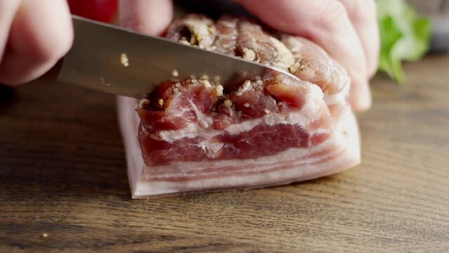 Close-up slicing of salted pork brisket