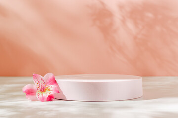 Empty podium with pink lily flower and aesthetic sunlight shadows. Background for cosmetic,...