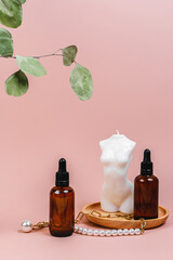 Oil body lotion, candle in the shape of a female body, jewelry, eucalyptus leaf. Spa. Bathroom cosmetics and accessories