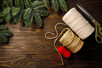 scissors, cream coloured and red twisted cotton ropes and burlap cord on dark wooden table...