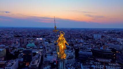 Aerial view of the statue of the Madonna on the central spire of the Duomo and the city's cathedral...