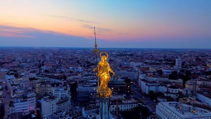 Aerial view of the statue of the Madonna on the central spire of the Duomo and the city's cathedral...