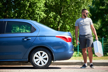 Young man looking for help with his stalled car. Male adult looking for the nearest petrol station....