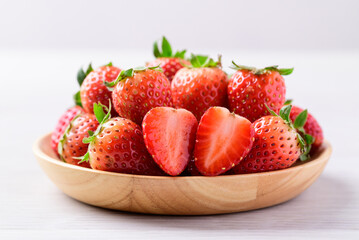Fresh strawberry fruit in wooden bowl on white background