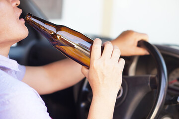 Close up drunk man hold bottle of beer to drink in car. Concept , Campaign for don't drive, don't...