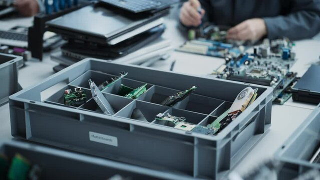 Close Up Shot Of Box With Motherboards From Old Laptops That Are Being Disassembled By Electronics Factory Workers. Process Of Recycling Computer Components For Production Of Modern Microchips.