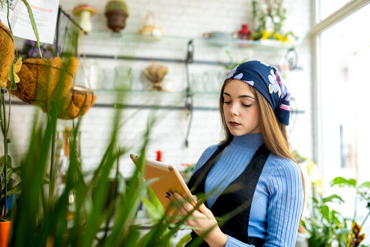 Female florist working in floral shop using tablet